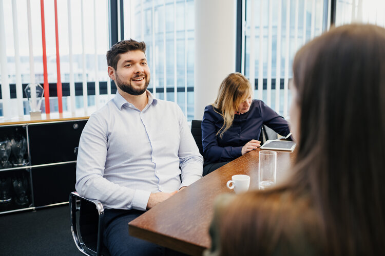 [Translate to Englisch:] Drei Personen sitzen an einem Besprechungstisch